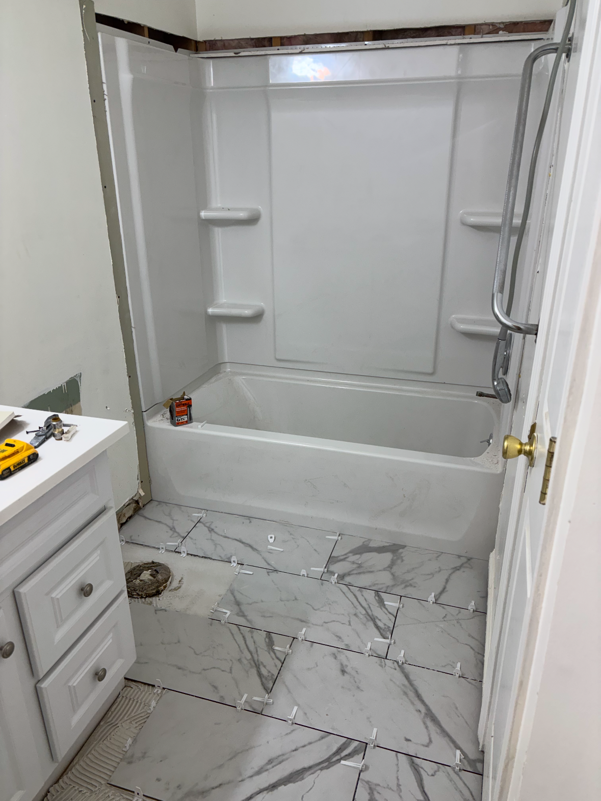 Completed bathroom with marble tile and new tub surround