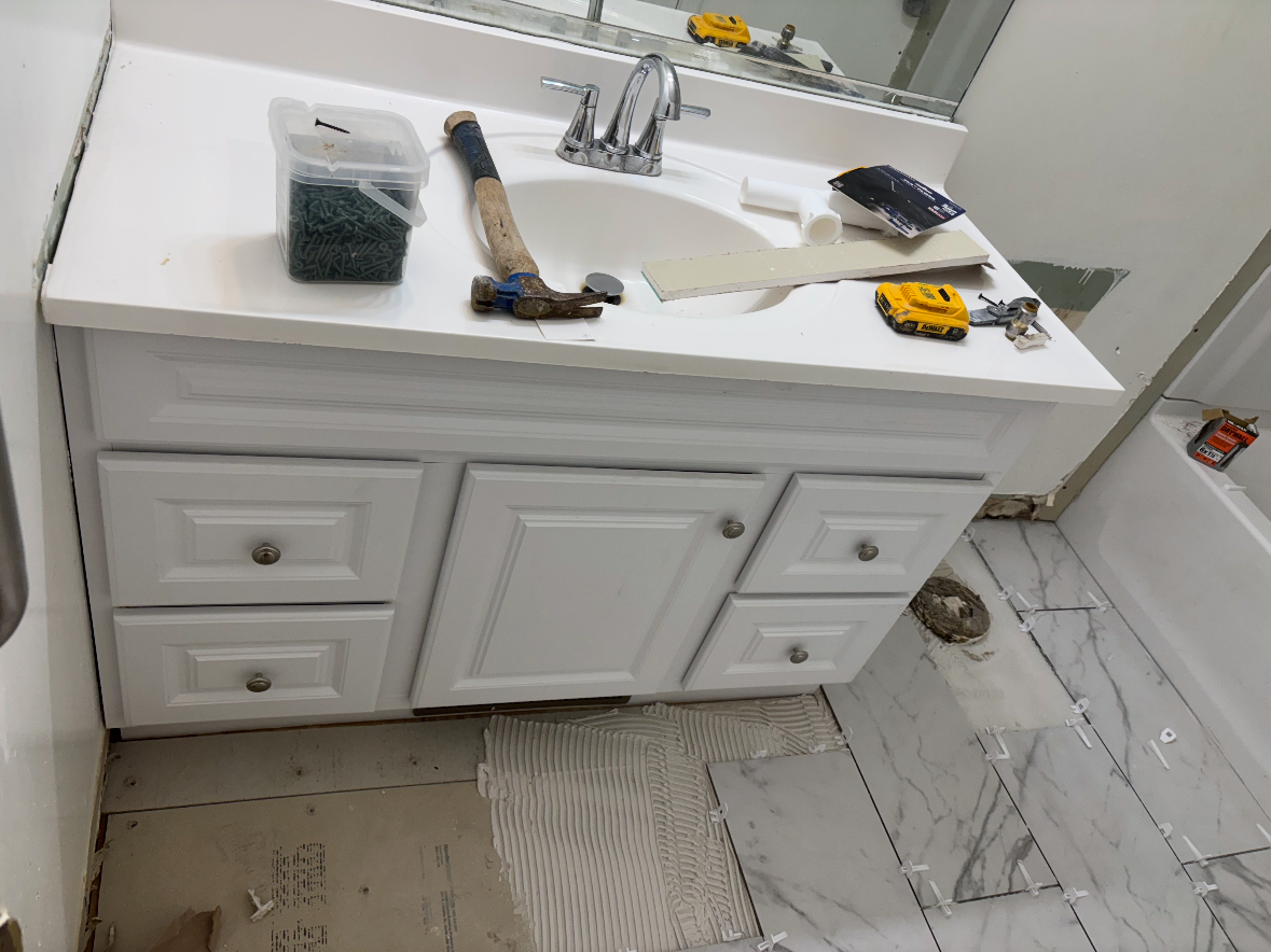 New vanity installed over in-progress marble tile floor